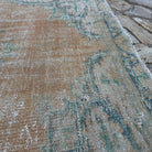 Close-up of the orange Turkish handknotted rug showing medallion details, hand-knotted weave, wool and cotton and low pile.