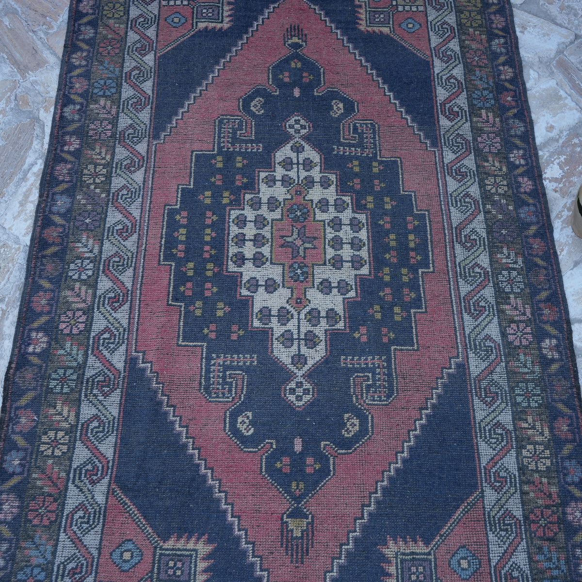 Close-up of the pink handknotted turkish rug showing traditional details, hand-knotted weave, wool and low pile.