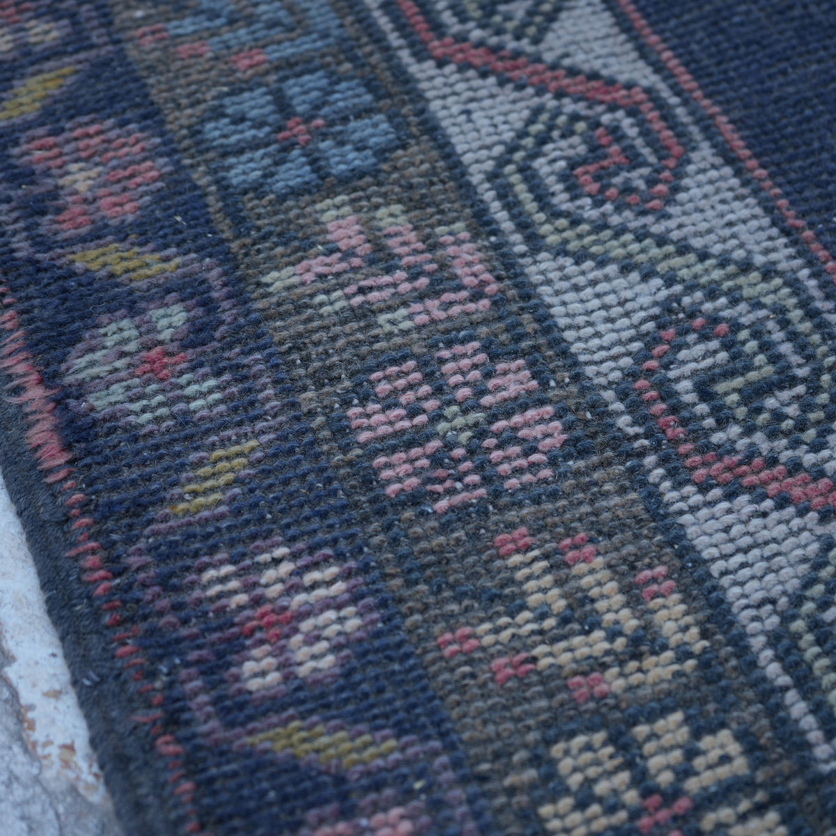 Pink 5' x 8' handknotted turkish rug in wool, shown on the floor.