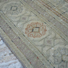 Beige 5' x 8' Turkish handknotted vintage rug in wool and cotton, shown on the floor.