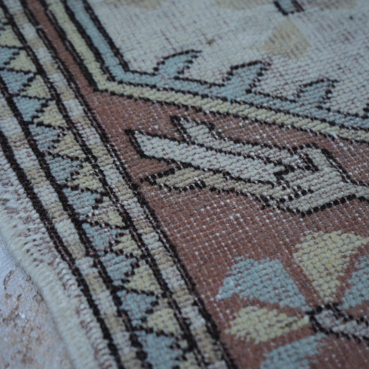 Beige 5' x 8' Turkish handknotted wool rug in wool, shown on the floor.