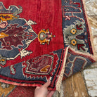 Close-up of the red Turkish handmade vintage carpet showing traditional details, hand-knotted weave, wool and low pile.