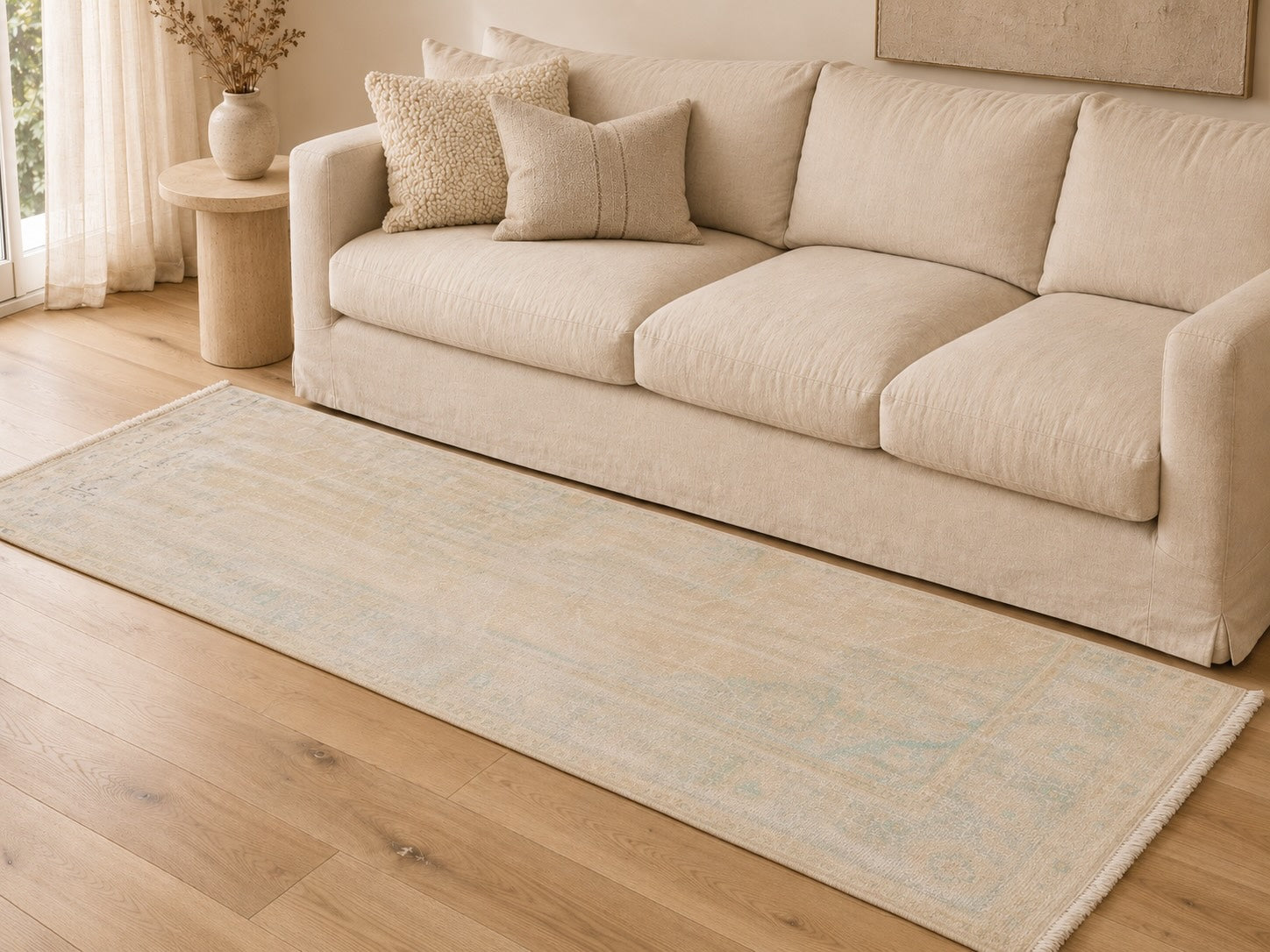 Harold vintage distressed beige, brown and white rug layered beneath a beige linen sofa, showing tonal rug and couch pairing for a soft neutral living room