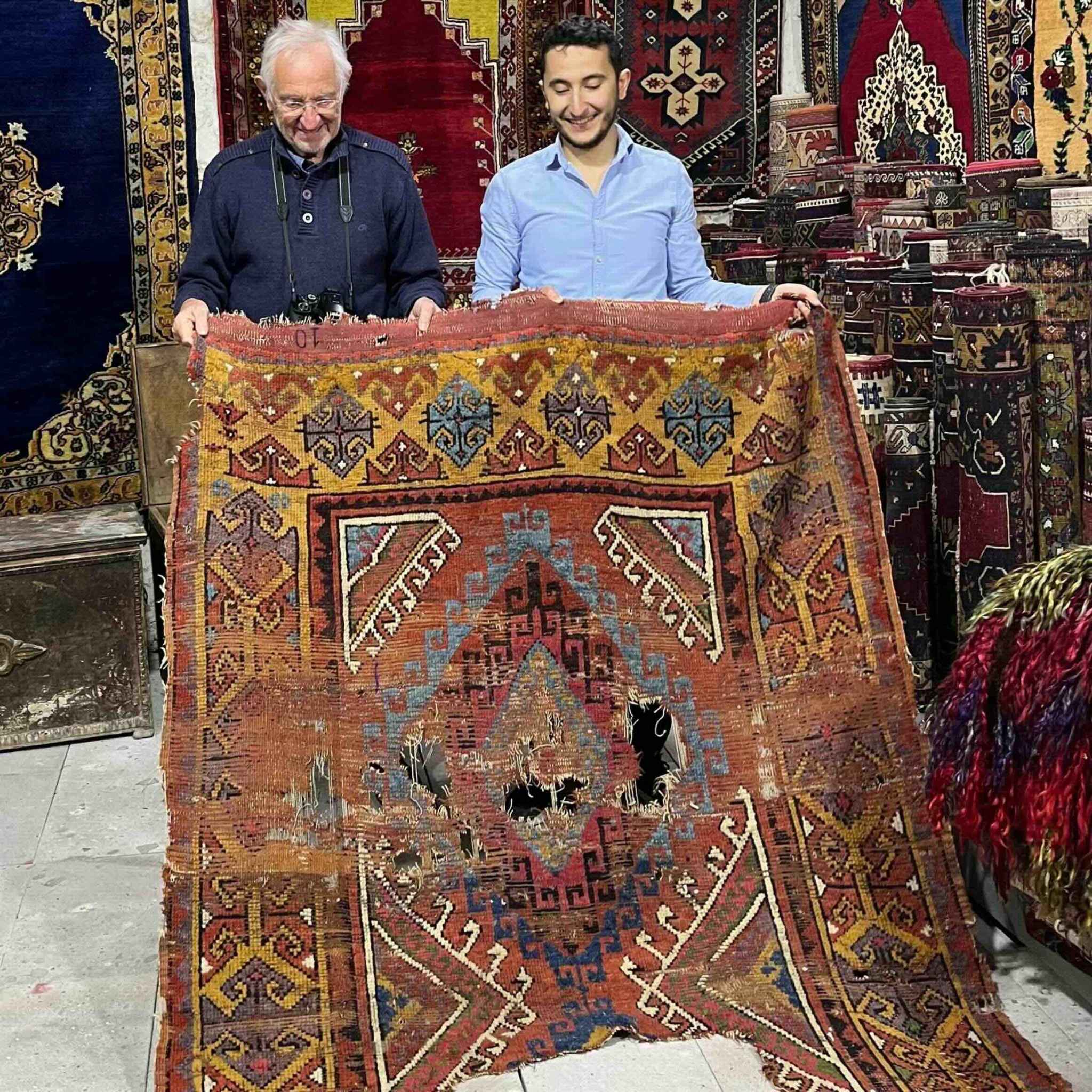 Kadir Cevik of Kirmen Rugs handling a hand-knotted wool rug in Anatolia, Turkey
