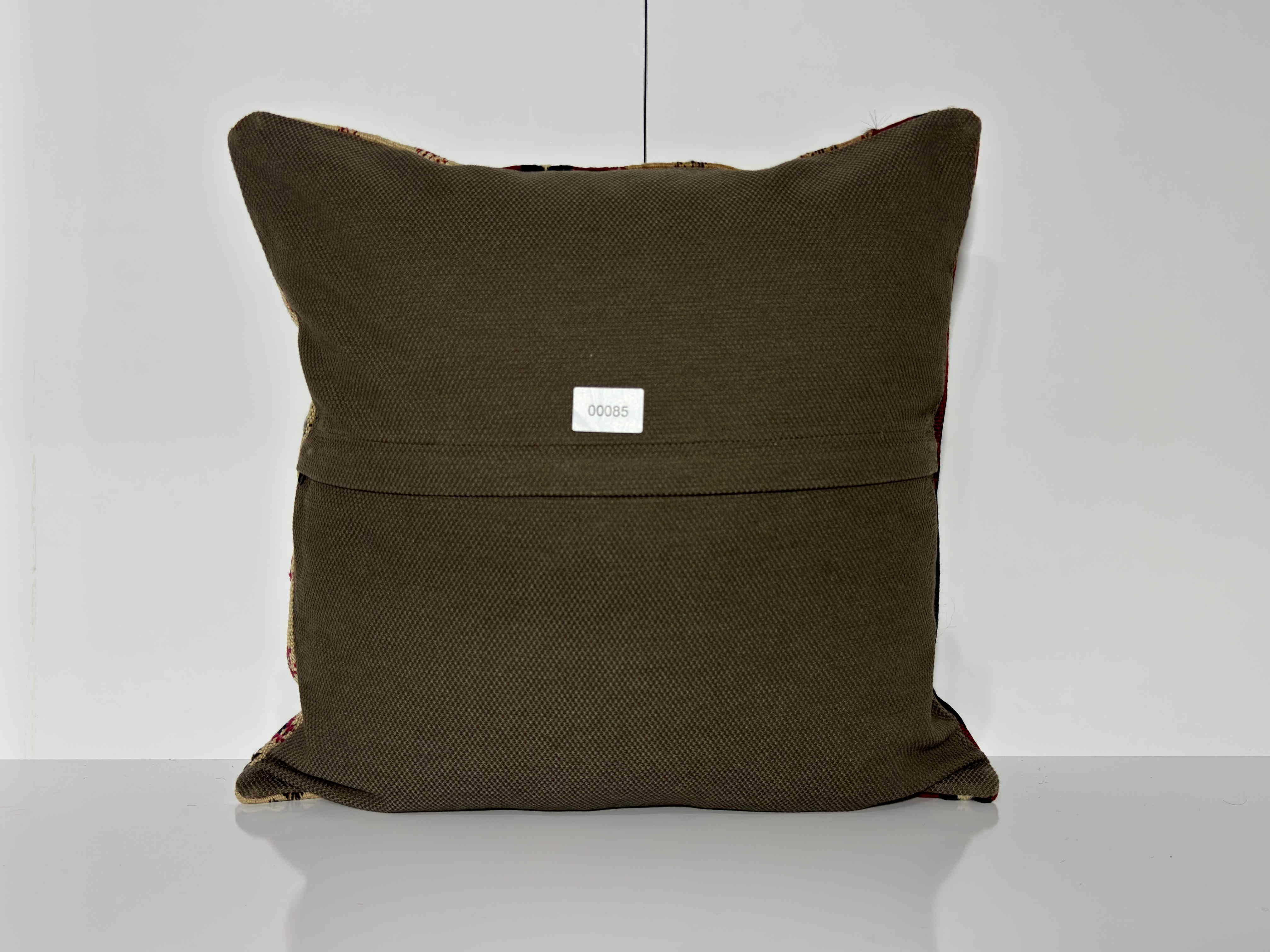 Close-up of the beige Turkish kilim pillow showing geometric details.