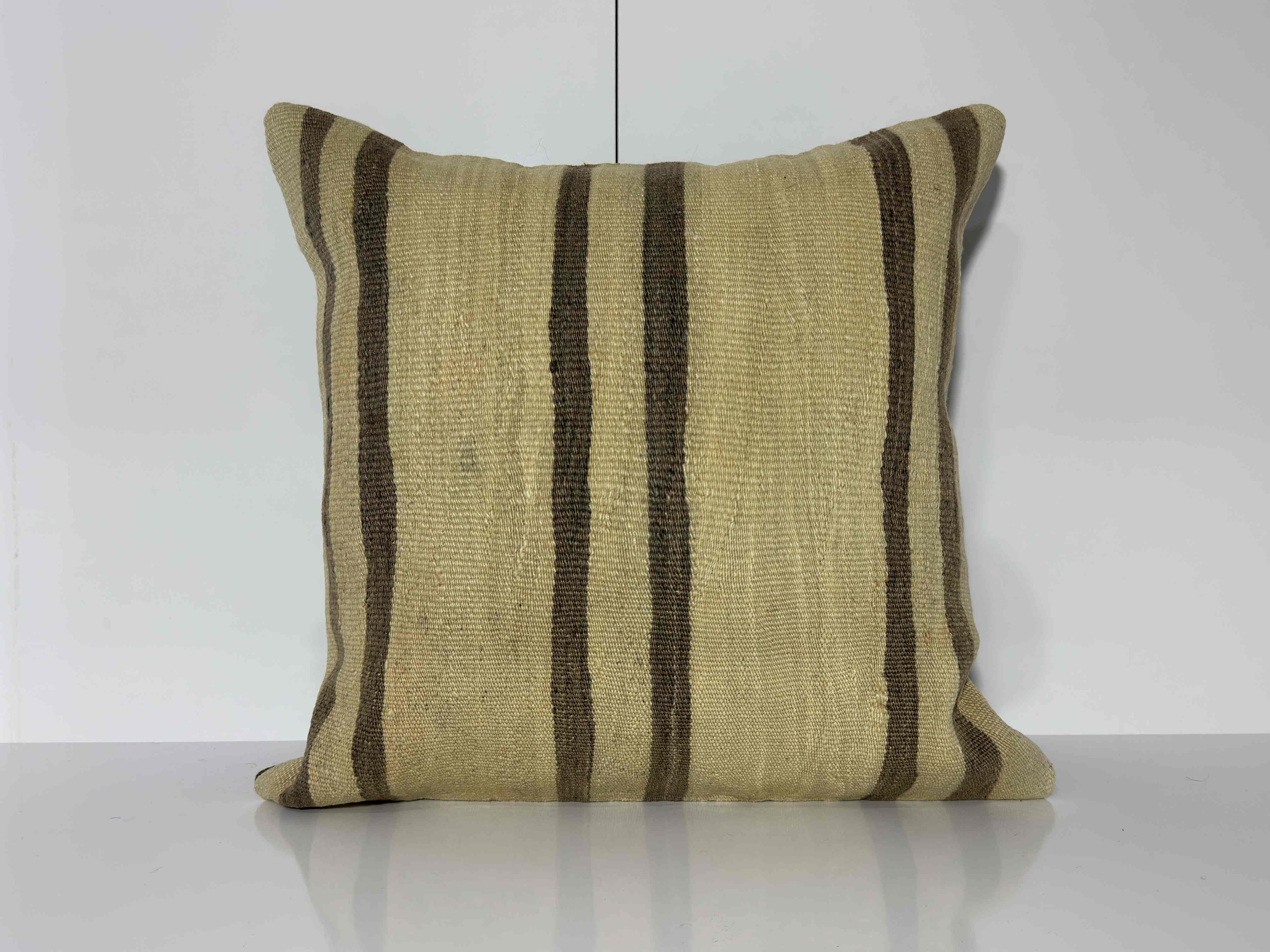 Beige Turkish kilim pillow, shown on the floor.