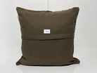 Close-up of the beige Turkish kilim pillow showing geometric details.