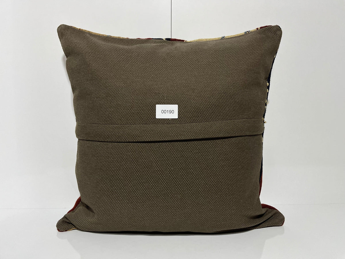 Close-up of the beige Turkish kilim pillow showing geometric details.