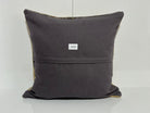 Close-up of the beige Turkish kilim pillow showing geometric details, low pile.