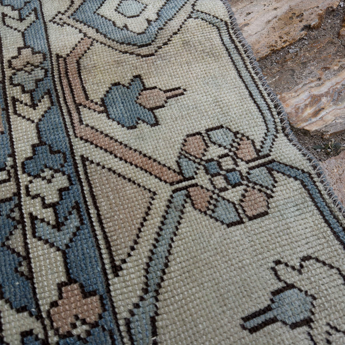 Close-up of the pale blue Turkish large area rug showing traditional details, hand-knotted weave, wool and cotton and low pile.