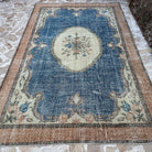 Blue 7' x 10' Turkish large medallion rug in wool and cotton, shown on the floor.