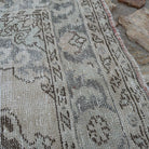 Close-up of the pale blue Turkish large traditional rug showing neutral details, hand-knotted weave, wool and cotton and low pile.
