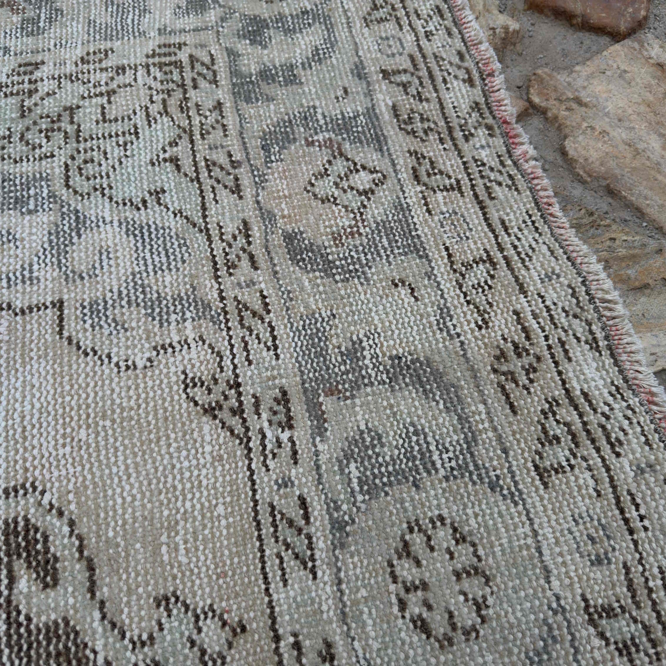 Close-up of the pale blue Turkish large traditional rug showing neutral details, hand-knotted weave, wool and cotton and low pile.