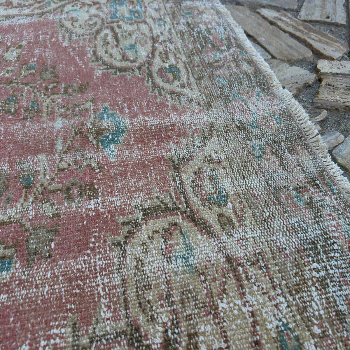 Close-up of the pink large turkish rug showing medallion details, hand-knotted weave, wool and cotton and low pile.