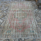 Pink 5' x 9' large turkish rug in wool and cotton, shown on the floor.