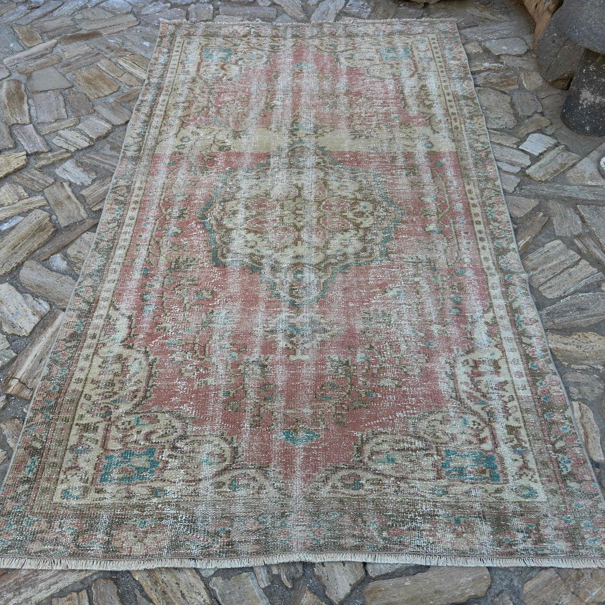 Pink 5' x 9' large turkish rug in wool and cotton, shown on the floor.