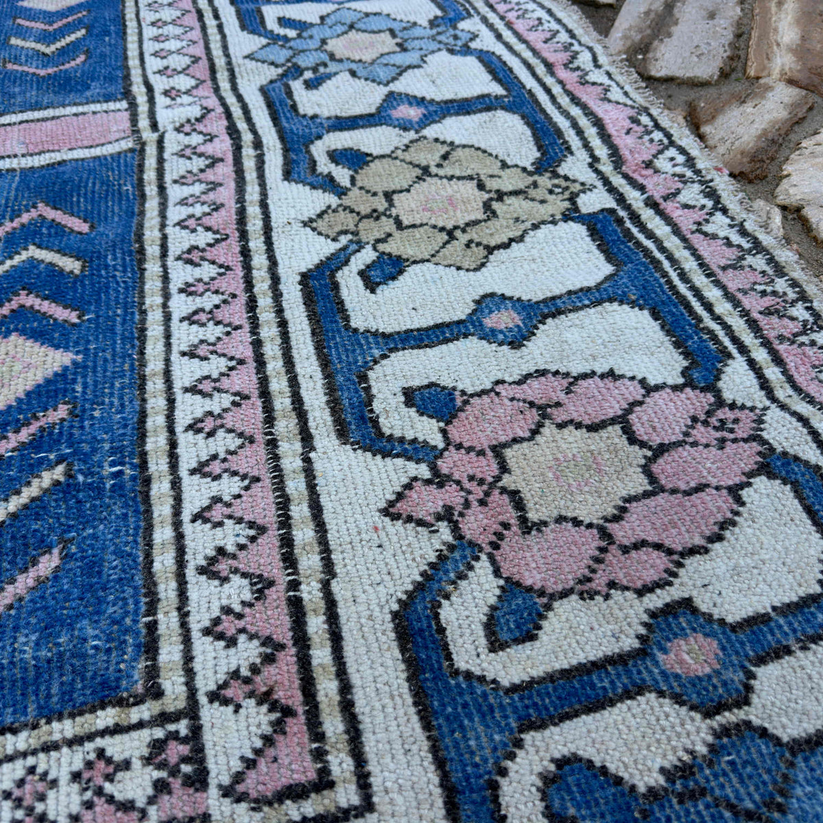 Close-up of the blue large turkish rug showing traditional details, hand-knotted weave, wool and cotton and low pile.