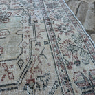 Close-up of the pale green large turkish rug showing medallion details, hand-knotted weave, wool and cotton and low pile.