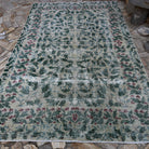 Green 7' x 10' large turkish rug in wool and cotton, shown on the floor.