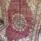 Red 7' x 10' large turkish rug in wool and cotton, shown on the floor.