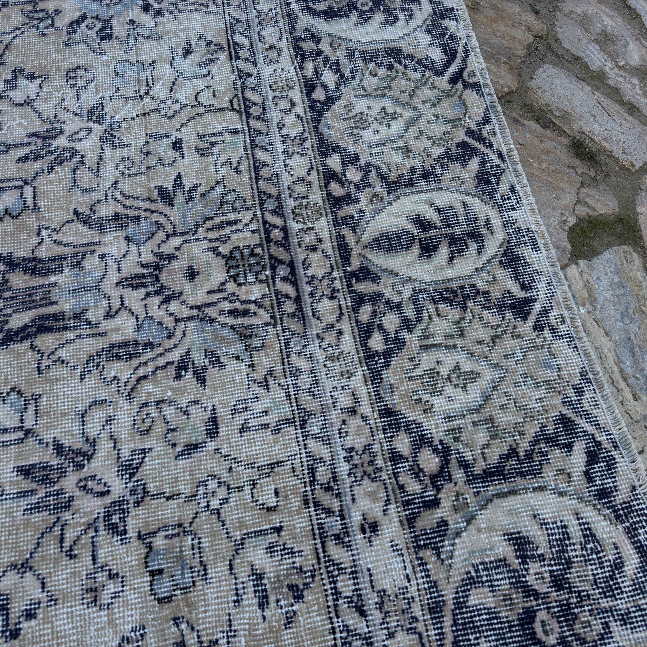 Close-up of the pale blue Turkish large vintage floral rug showing neutral and floral details, hand-knotted weave, wool and cotton and low pile.