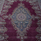 Close-up of the burgundy large vintage persian rug showing medallion details, hand-knotted weave, wool and cotton and low pile.