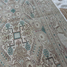 Close-up of the beige large vintage persian rug showing neutral details, hand-knotted weave, wool and cotton and low pile.