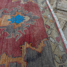 Close-up of the pale red Turkish large vintage rug showing traditional details, hand-knotted weave, wool and cotton and low pile.
