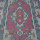 Close-up of the pale pink Turkish large wool rug showing geometric details, hand-knotted weave, wool and low pile.
