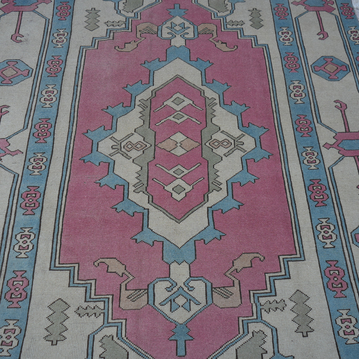 Close-up of the pale pink Turkish large wool rug showing geometric details, hand-knotted weave, wool and low pile.