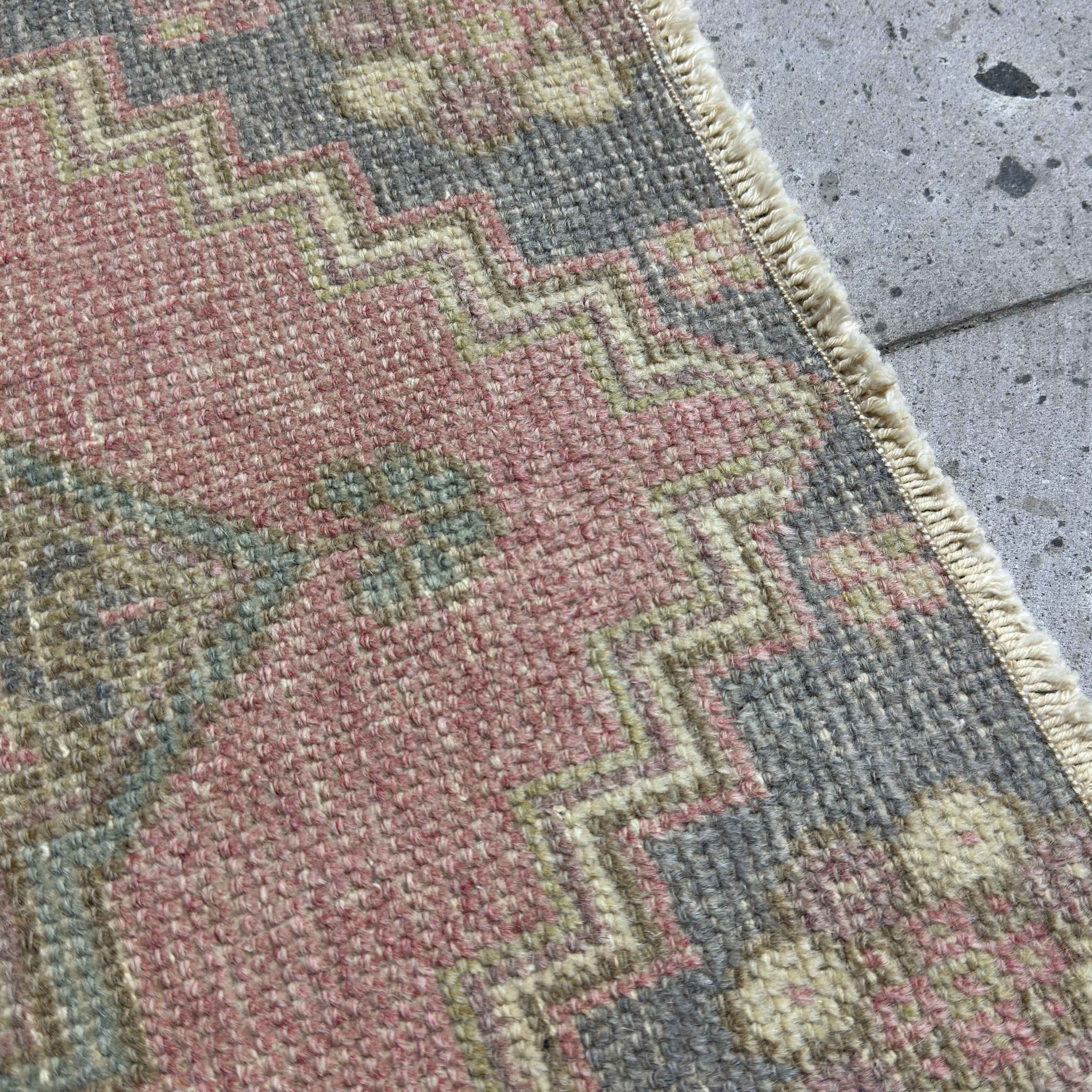 Close-up of the pink Turkish mini anatolian rug showing traditional details, hand-knotted weave, wool and cotton and low pile.