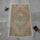 Pink 2' x 3' Turkish mini anatolian rug in wool and cotton, shown on the floor.