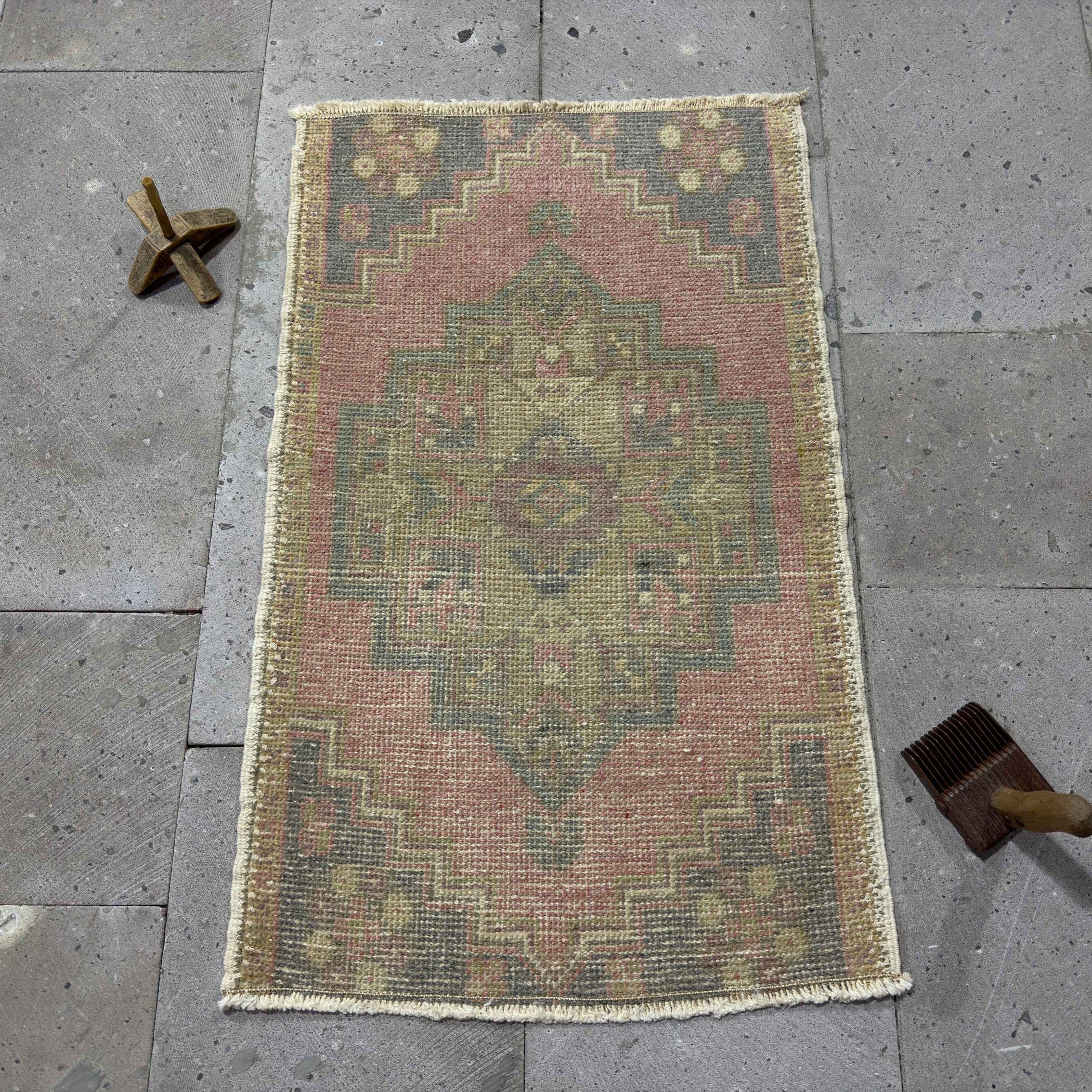 Pink 2' x 3' Turkish mini anatolian rug in wool and cotton, shown on the floor.