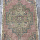 1970s pink Turkish mini anatolian rug with traditional design, hand-knotted weave and low pile.