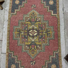 1970s red Turkish mini anatolian rug with traditional design, hand-knotted weave and low pile.