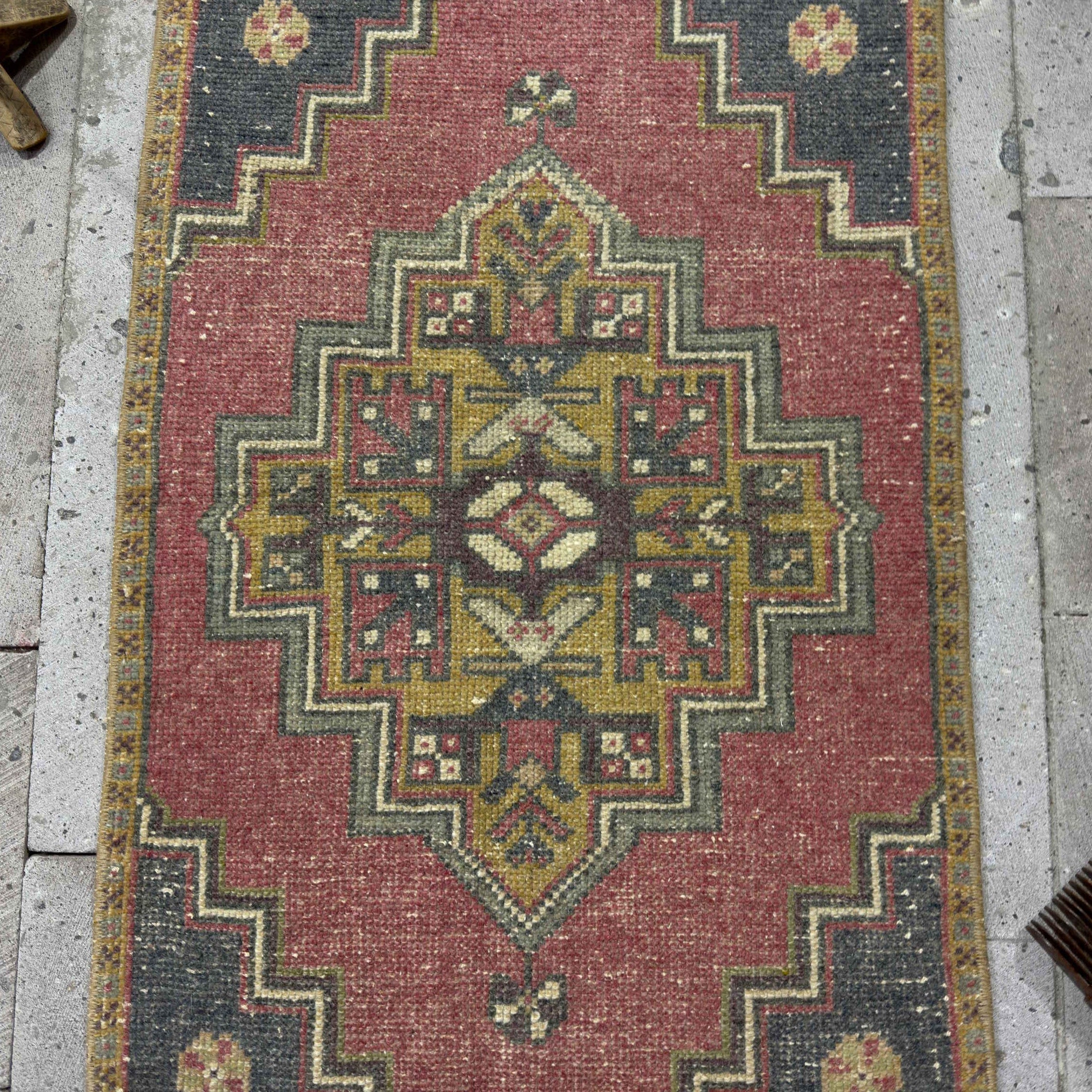 1970s red Turkish mini anatolian rug with traditional design, hand-knotted weave and low pile.
