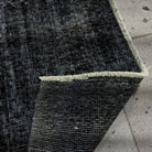 Close-up of the black Turkish mini overdyed rug showing overdyed details, hand-knotted weave, wool and cotton and low pile.