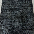 1970s black Turkish mini overdyed rug with overdyed design, hand-knotted weave and low pile.