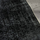 Close-up of the black Turkish mini runner rug showing overdyed details, hand-knotted weave, wool and cotton and low pile.