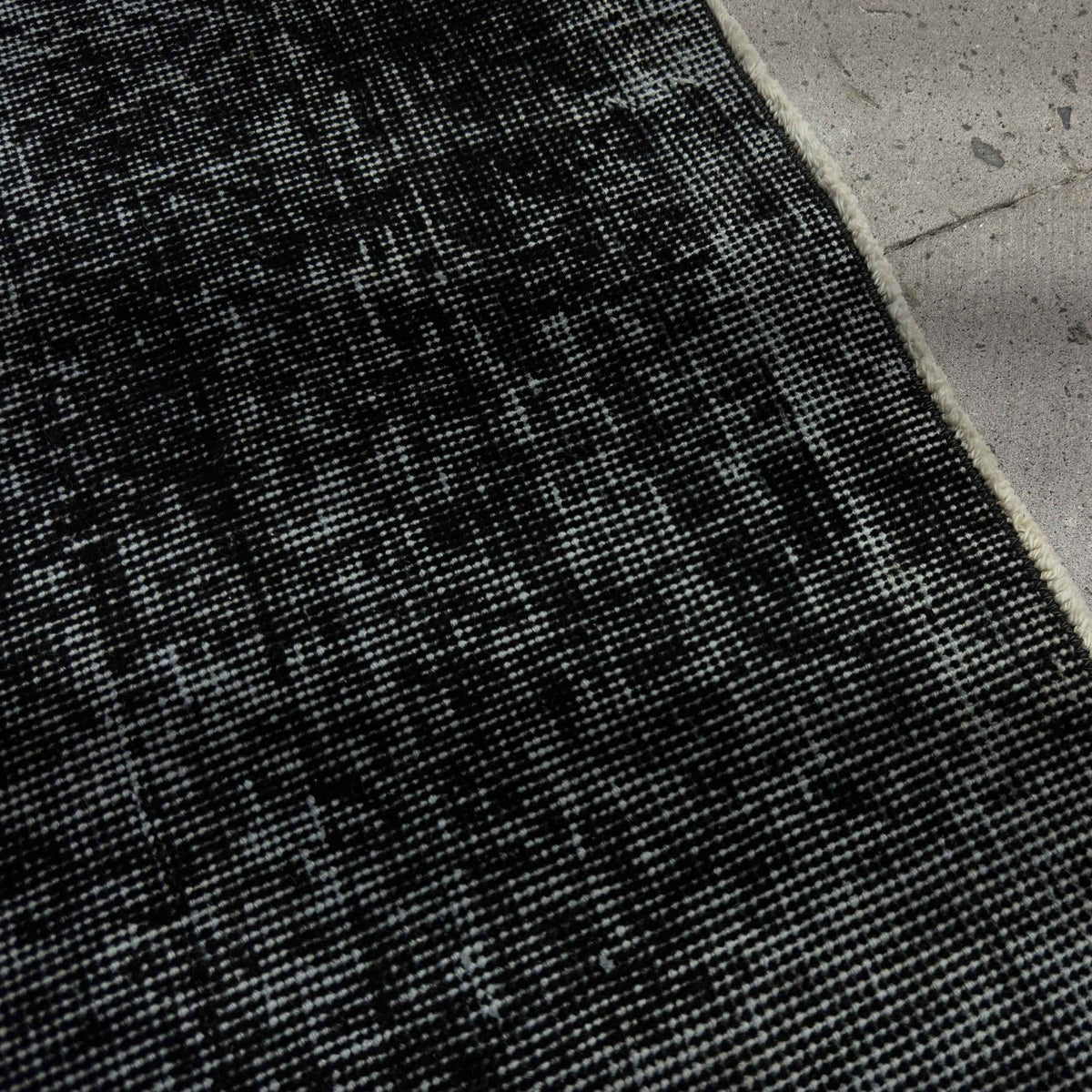Close-up of the black Turkish mini runner rug showing overdyed details, hand-knotted weave, wool and cotton and low pile.
