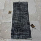 Black 2' x 4' Turkish mini runner rug in wool and cotton, shown on the floor.