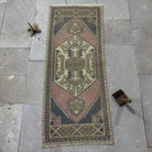 Pink 2' x 4' Turkish mini runner vintage rug in wool and cotton, shown on the floor.