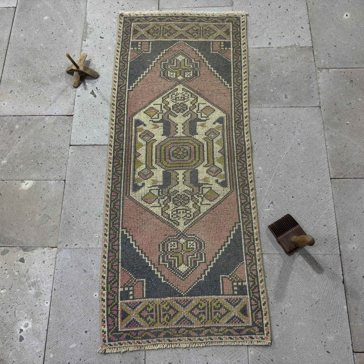 Pink 2' x 4' Turkish mini runner vintage rug in wool and cotton, shown on the floor.