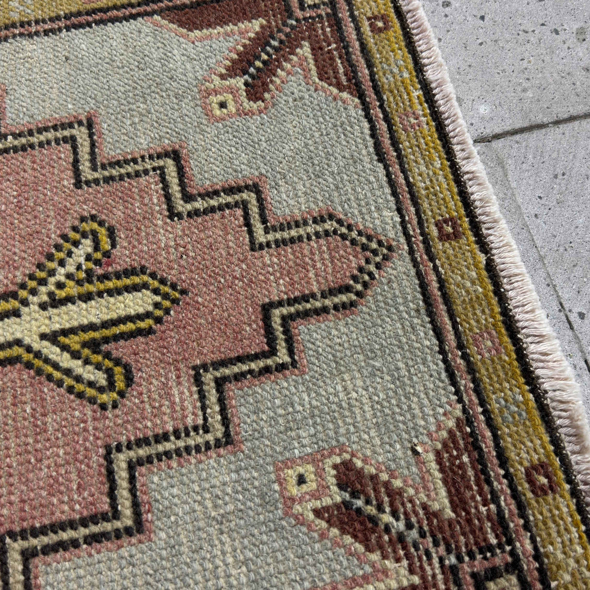 Close-up of the pink mini turkish carpet showing medallion details, hand-knotted weave, wool and cotton and low pile.