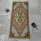 pink 2' x 3' mini turkish carpet in wool and cotton, shown on the floor.