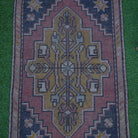 Close-up of the red mini turkish rug showing traditional details, hand-knotted weave, wool and cotton and low pile.