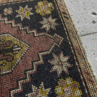 Close-up of the red mini turkish rug showing traditional details, hand-knotted weave, wool and cotton and low pile.