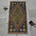 Red 2' x 3' mini turkish rug in wool and cotton, shown on the floor.