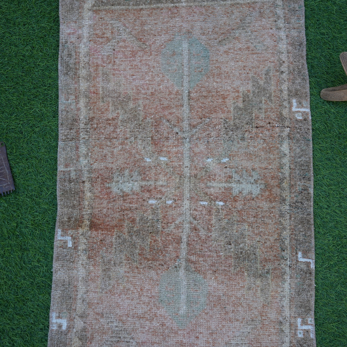 Close-up of the brown Turkish mini vintage rug showing traditional details, hand-knotted weave, wool and cotton and low pile.