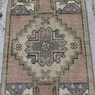 1970s pink Turkish mini vintage rug with traditional design, hand-knotted weave and low pile.